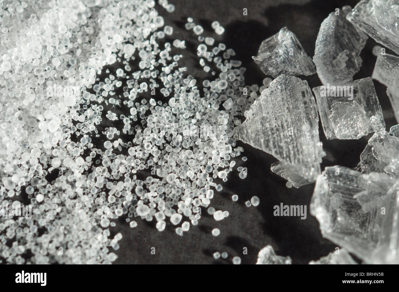 Macro close-up of Table salt rounded grains juxtaposed with crystalized sea salt. Stock Photo