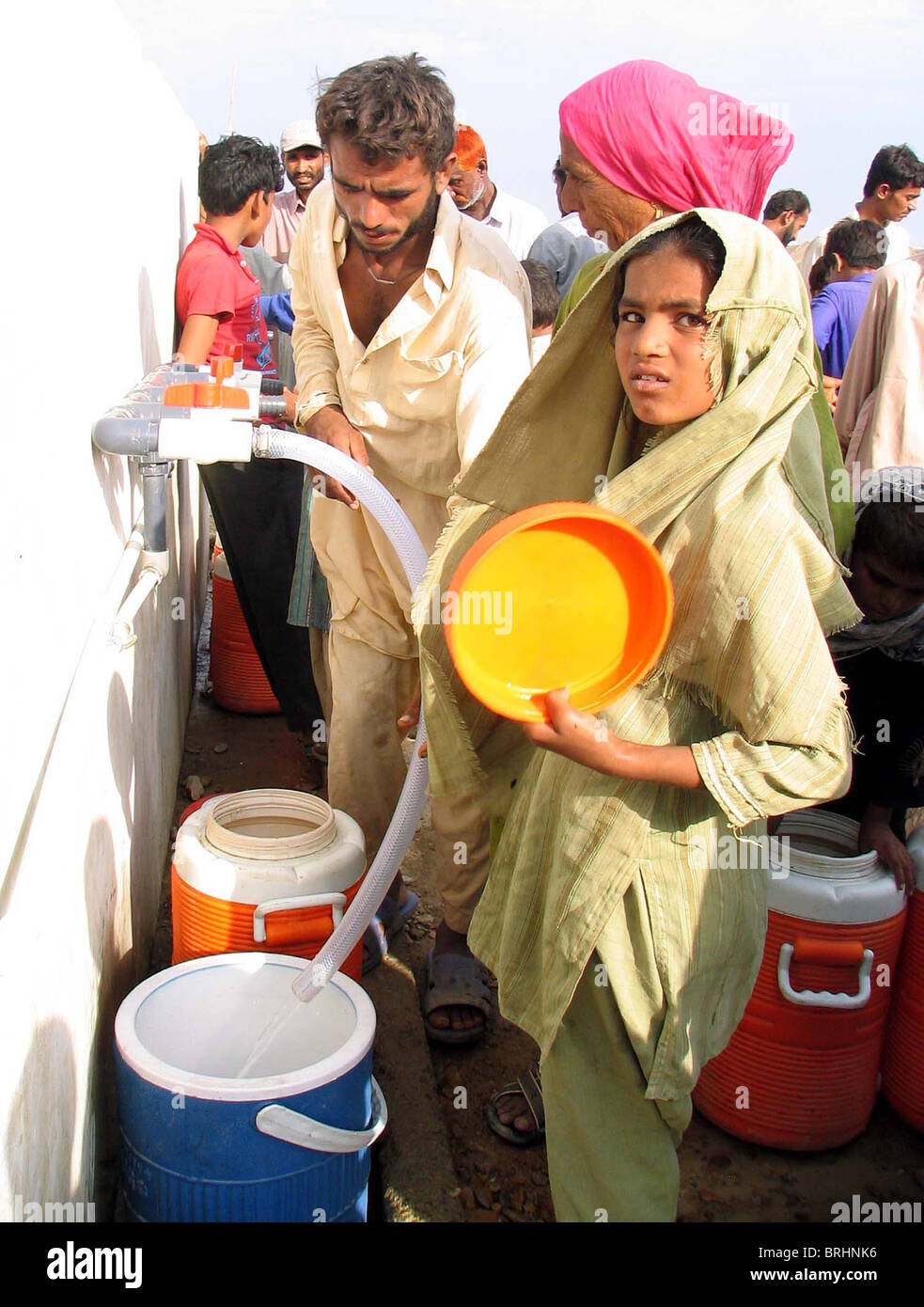 Flood affected people fill their drinking water coolers at drinking water tank at flood affectees relief camp Stock Photo