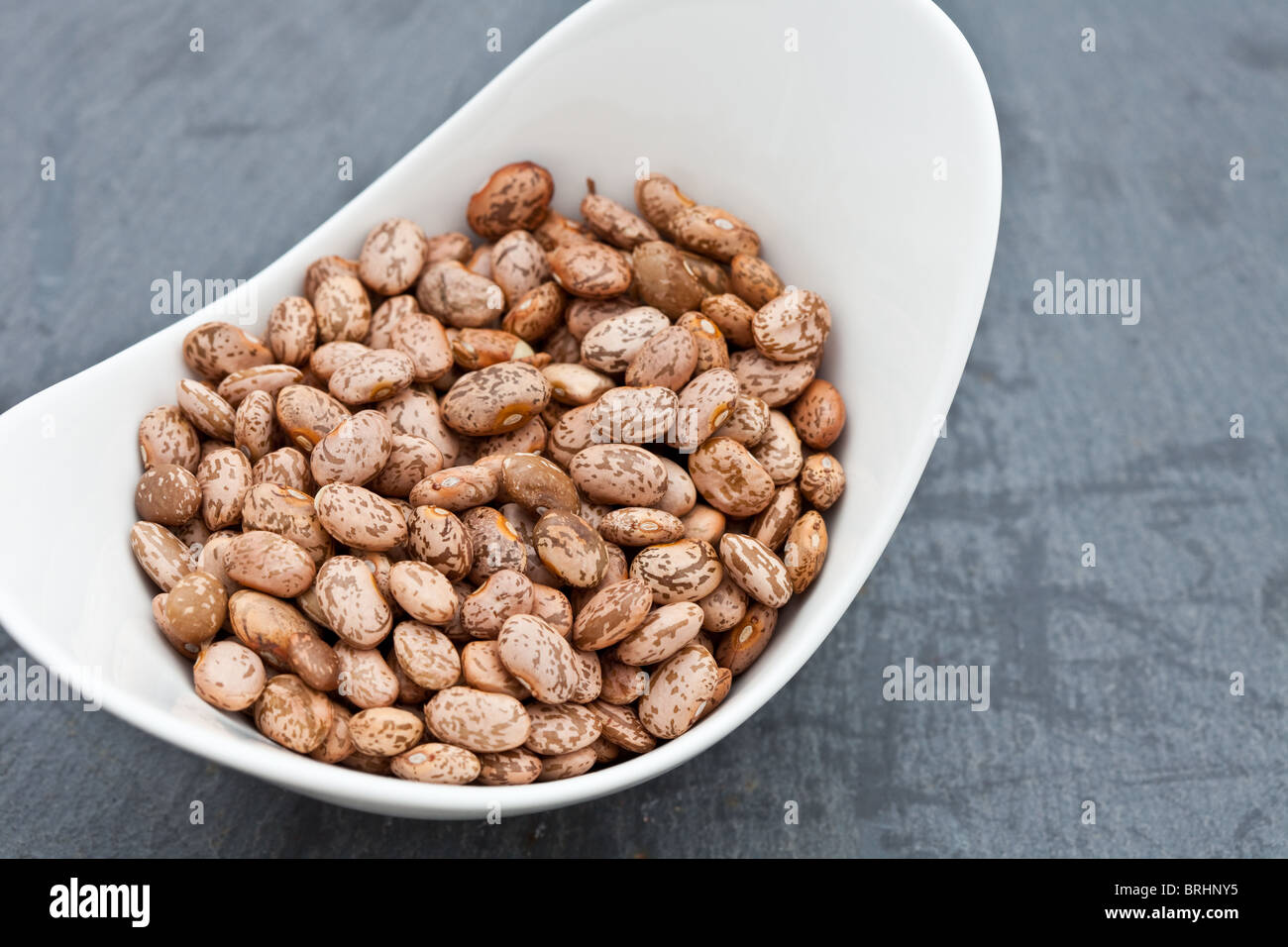 Dried pinto beans in a white dish Stock Photo Alamy