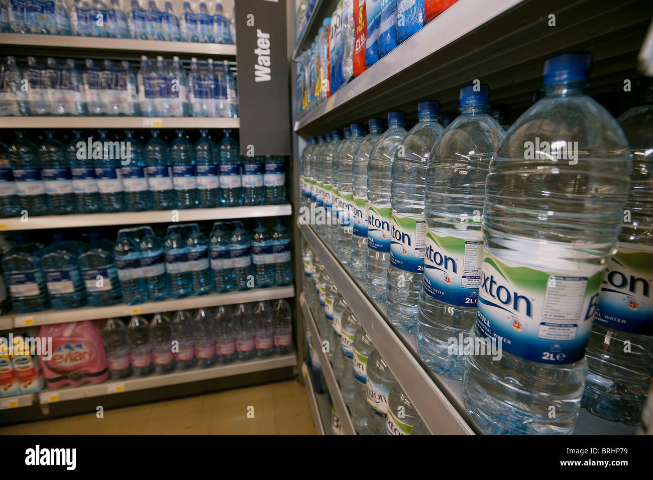 Bottled mineral water for sale in a supermarket stacked on shelf, UK Stock Photo