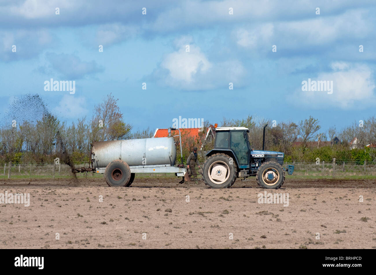 Tractor spreading manure to fertilize field, Texel, the Netherlands