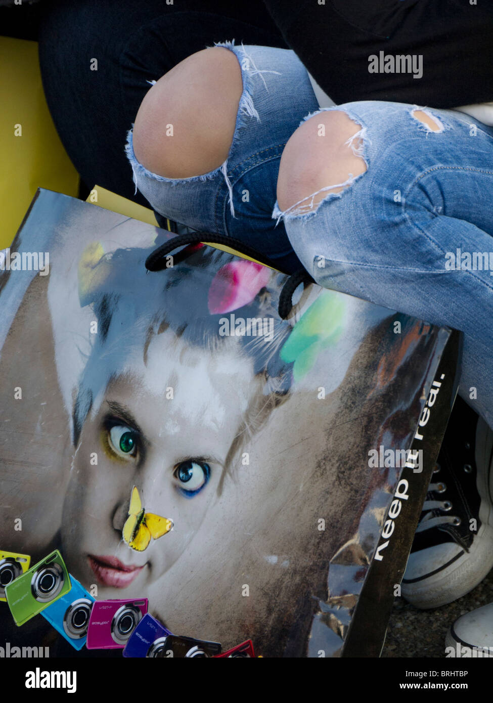 Girl student with torn denim jeans showing her knees, and a fashion