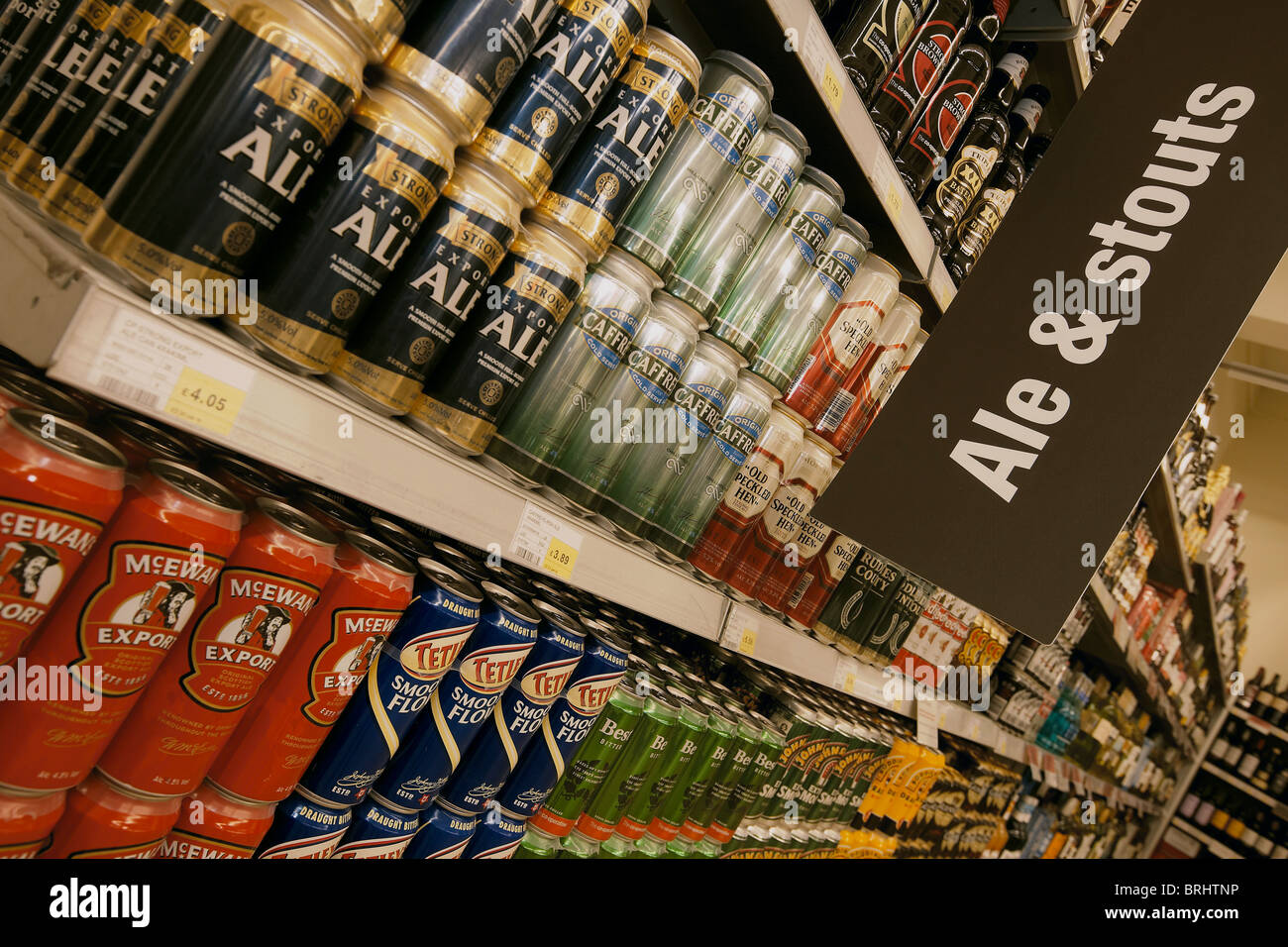 Selection of cans and bottles of beer for sale stacked on a supermarket