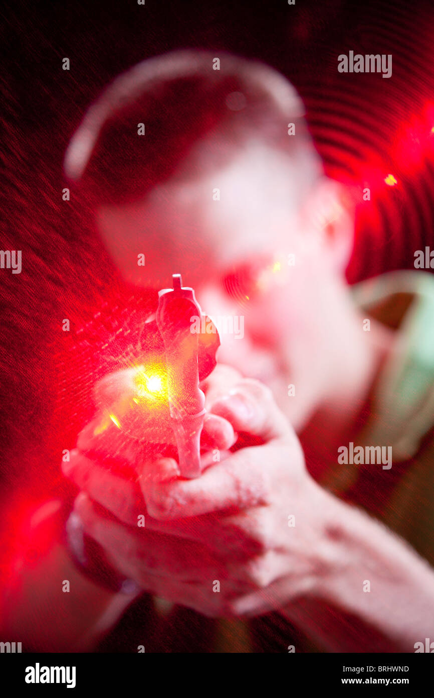 Ocala, FL - July 2009 - Young man pointing pistol with laser grip at camera. Stock Photo