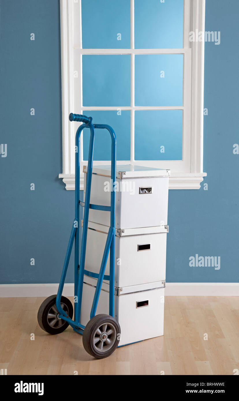 dolly with boxes stacked for moving in room Stock Photo