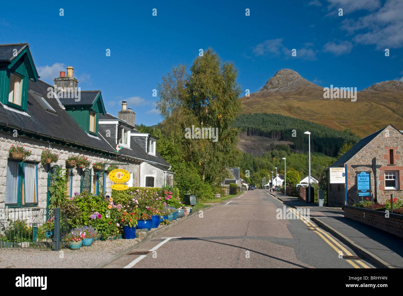 The village main street in Glencoe, beneath the distinctive Pap of Glen Coe Mountain. Scotland.  SCO 6805. Stock Photo