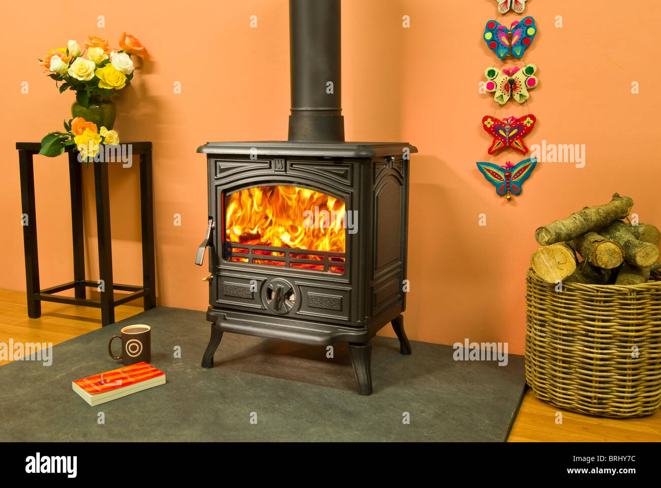 A Franco Belge Montfort wood burning stove with lovely flames and log  basket Stock Photo - Alamy