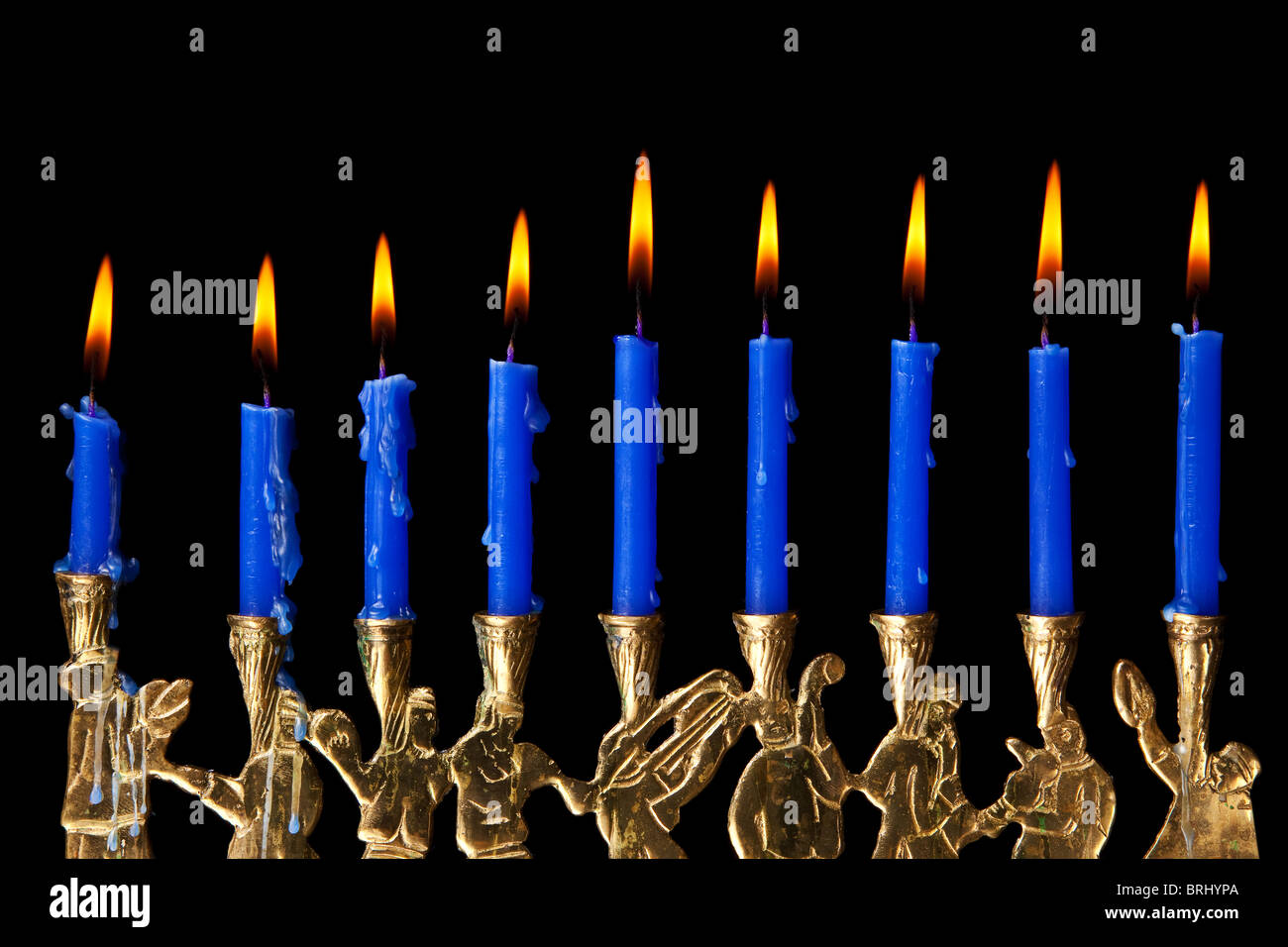 burning hanukkah candles in a menorah on black background Stock Photo