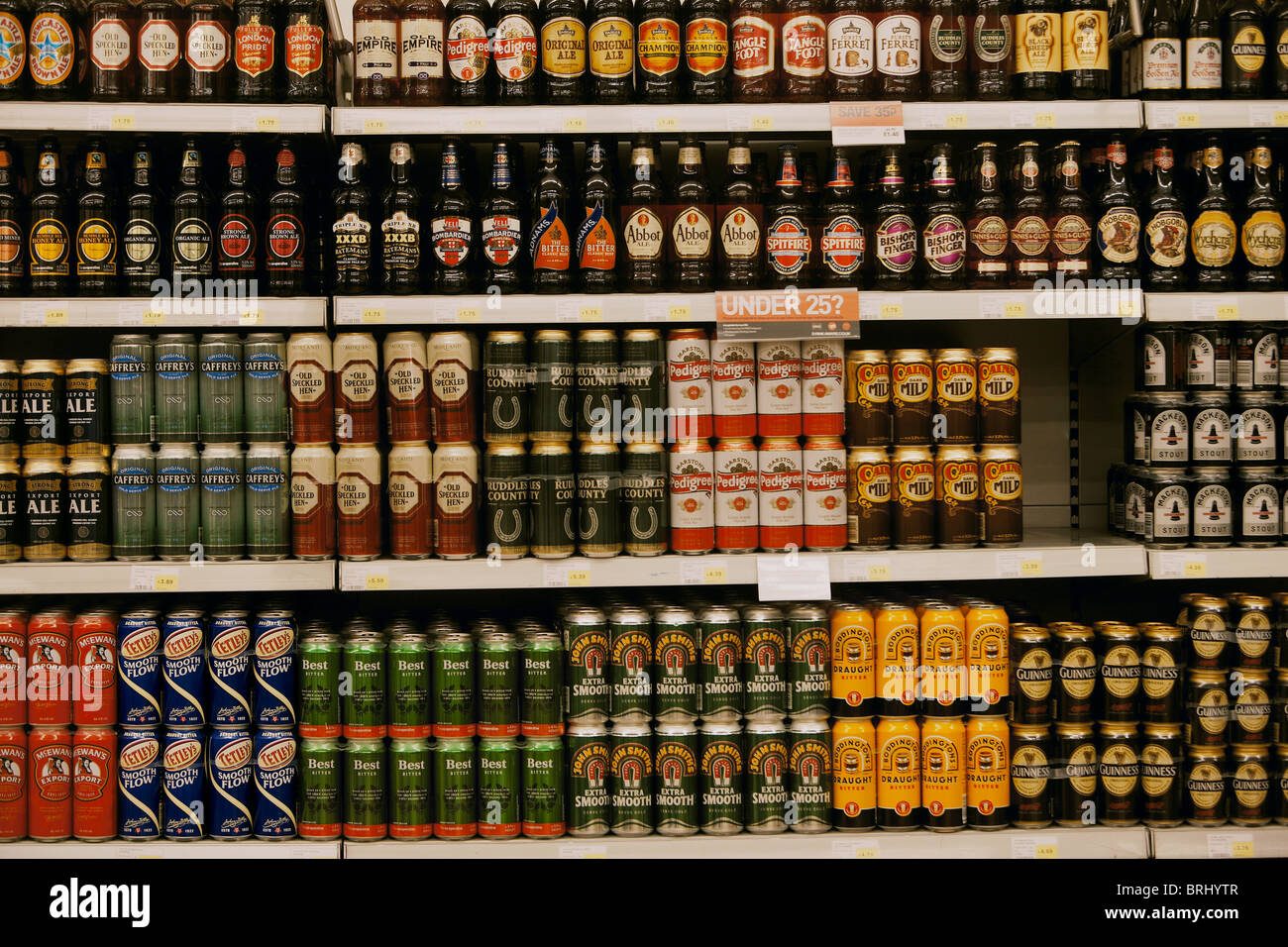 Selection of cans and bottles of beer for sale stacked on a supermarket