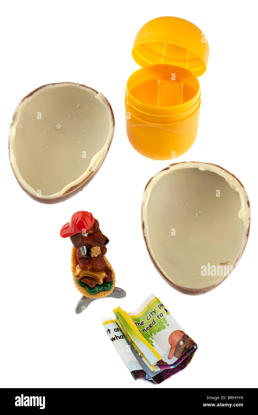 Kinder Surprise chocolate egg unwrapped and broken into two halves with toy and plastic container Stock Photo