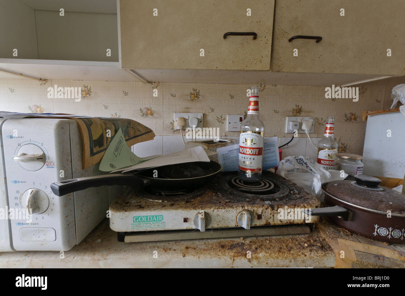 Empty vodka bottles on a very dirty kitchen worktop Stock Photo