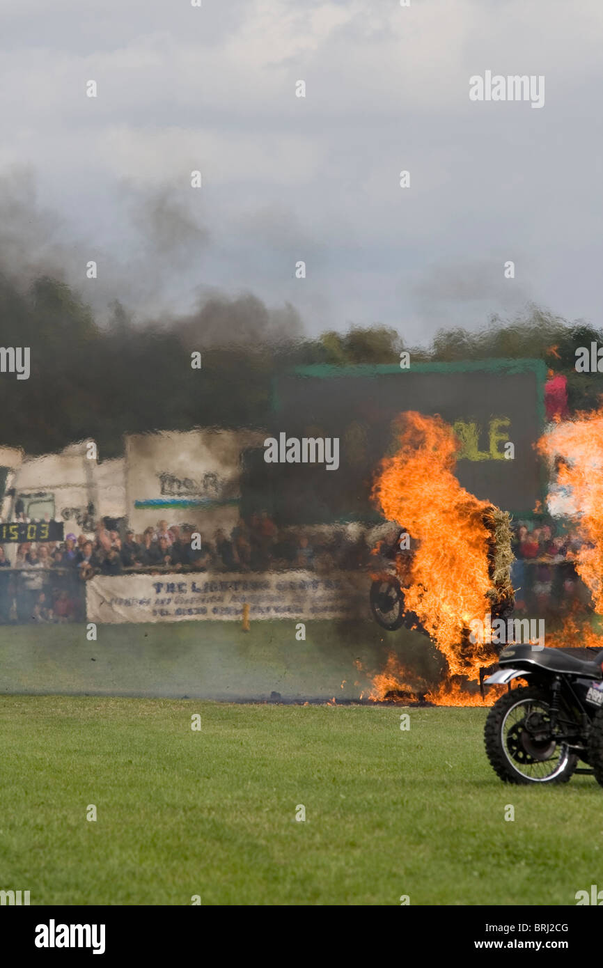 The Royal Signals White Helmets motorcycle display team. Riding between burning bales of hay Stock Photo
