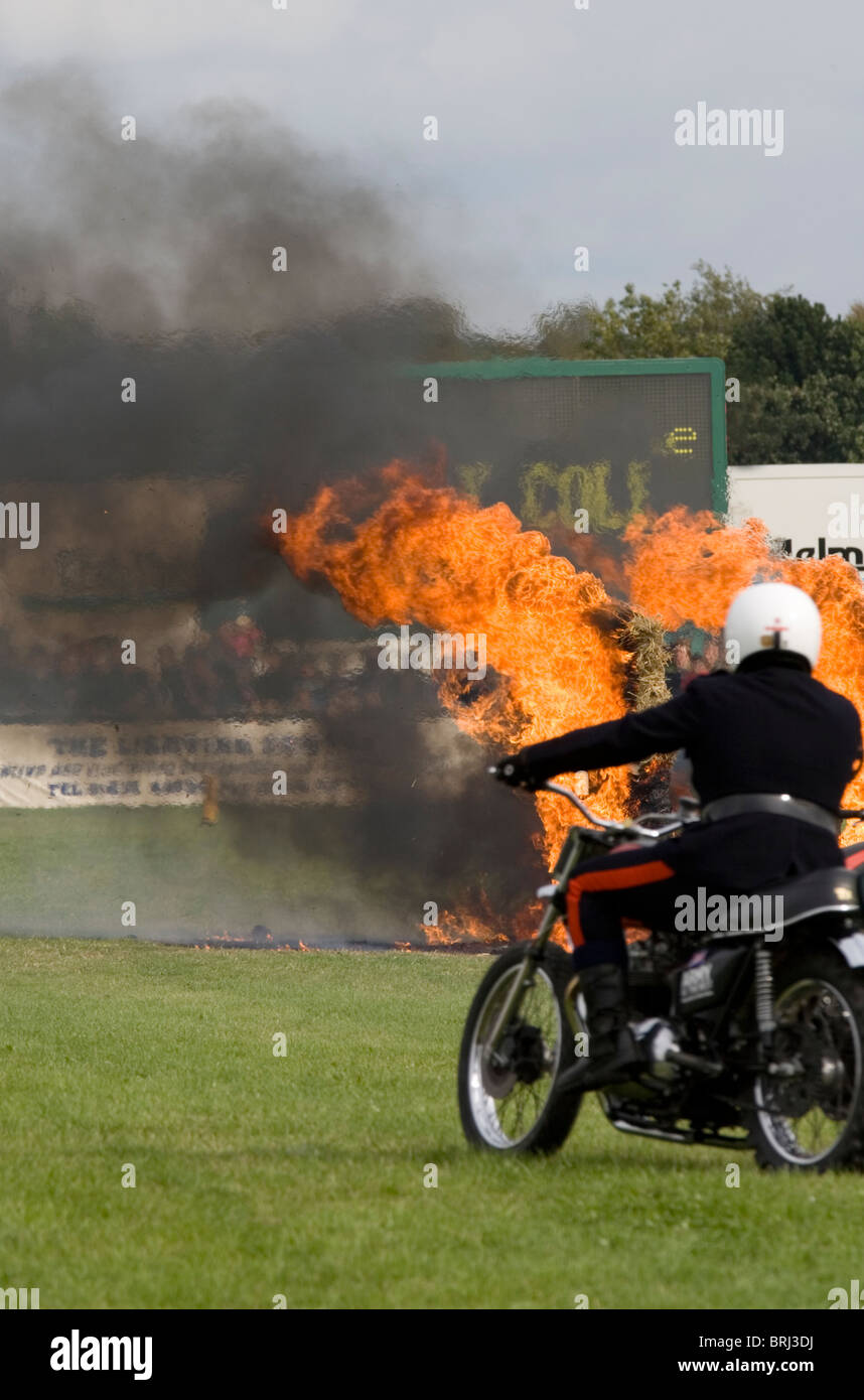 The Royal Signals White Helmets motorcycle display team. Riding between burning bales of hay Stock Photo