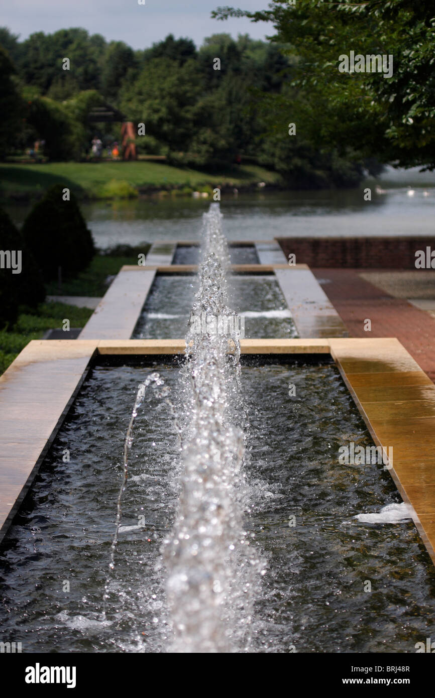 Looking downhill at a long fountain at Chicago Botanic Gardens, with three levels and one errant water jet. Stock Photo