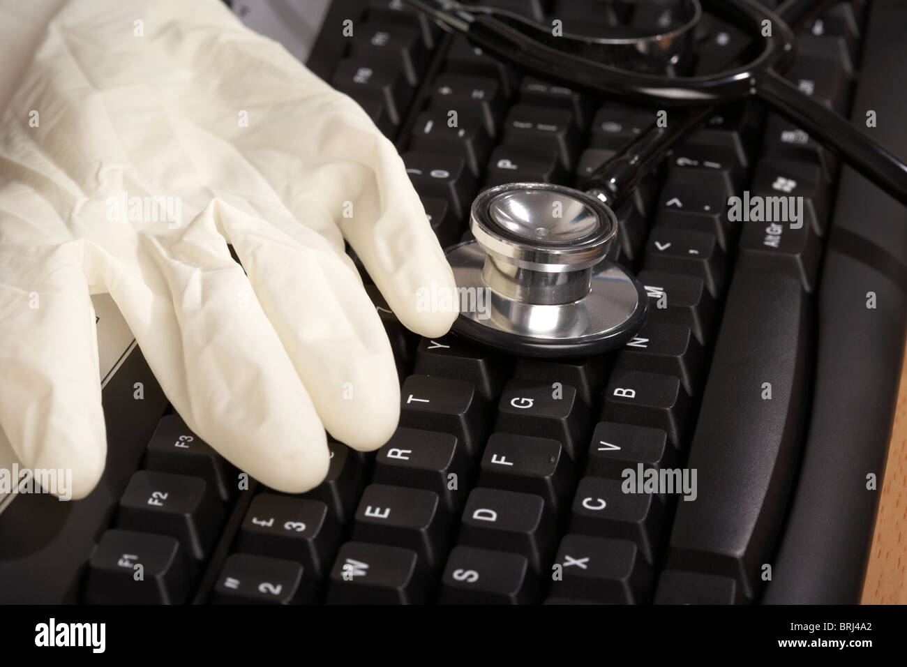 stethoscope and rubber glove on a computer keyboard Stock Photo