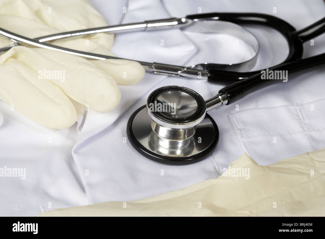 stethoscope rubber gloves on white medical lab coat doctors coat Stock Photo