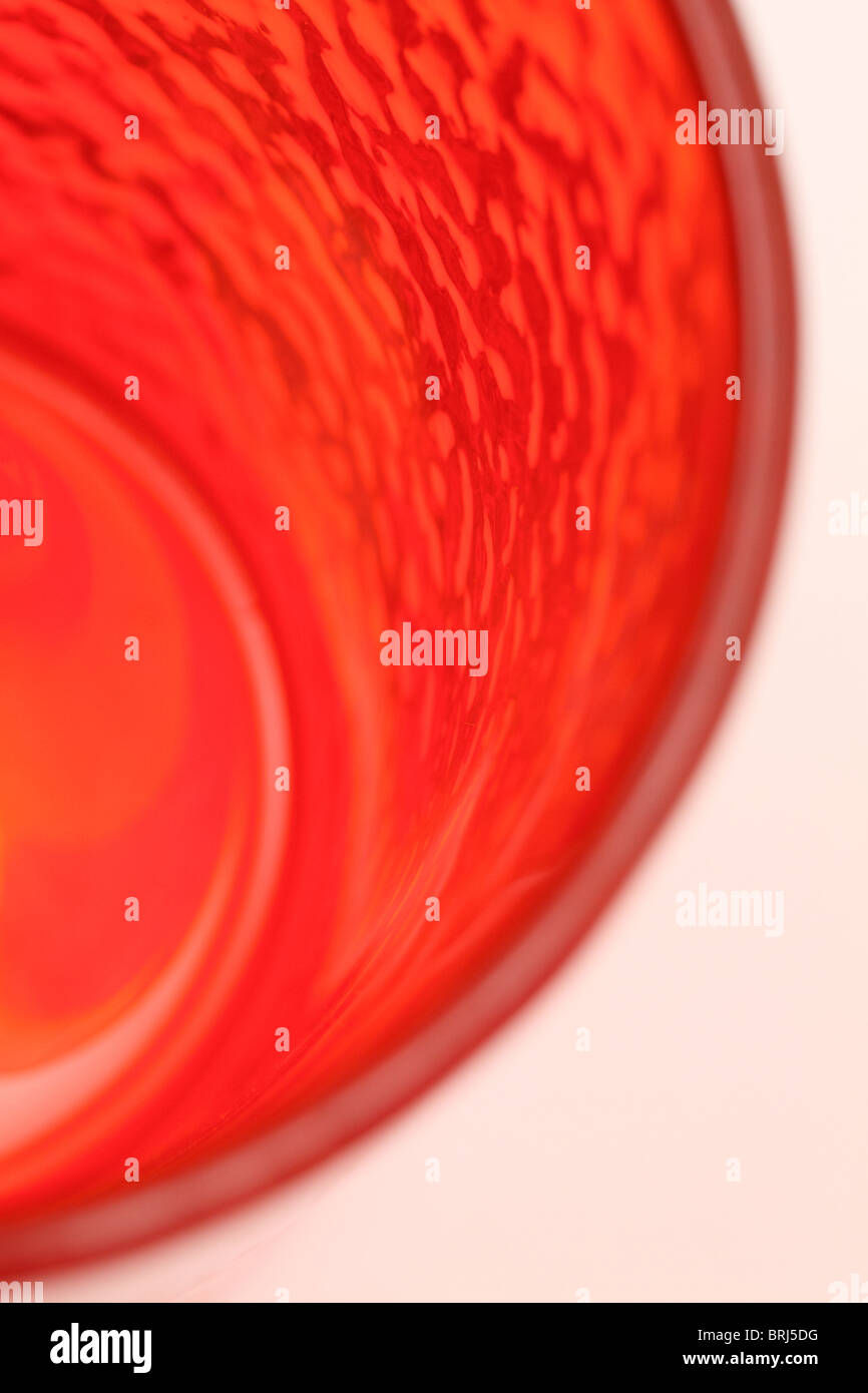 Red coloured glass tumbler with frosted type pattern Stock Photo