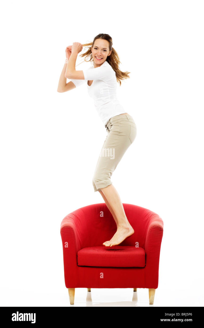 Young woman jumping on a chair Stock Photo Alamy