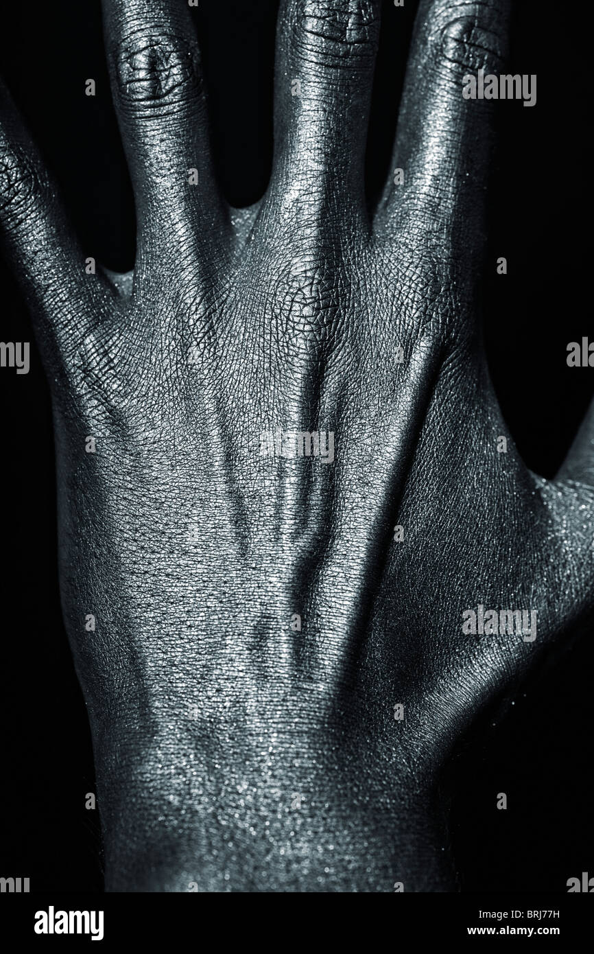 Man's hand in silver paint on black background closeup Stock Photo