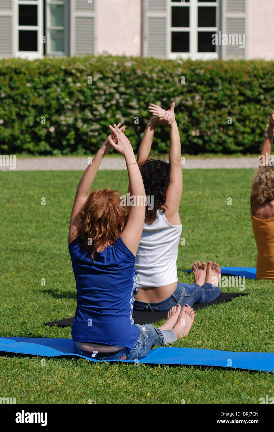young women doing yoga stretching exercises outdoor Stock Photo