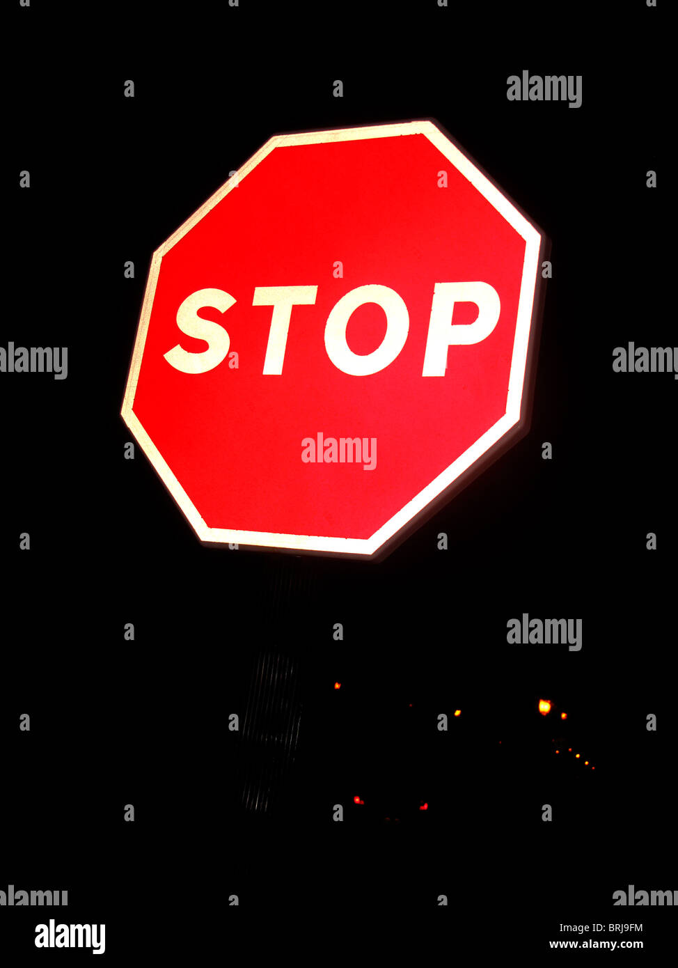 Octagonal red stop sign against dark background Stock Photo