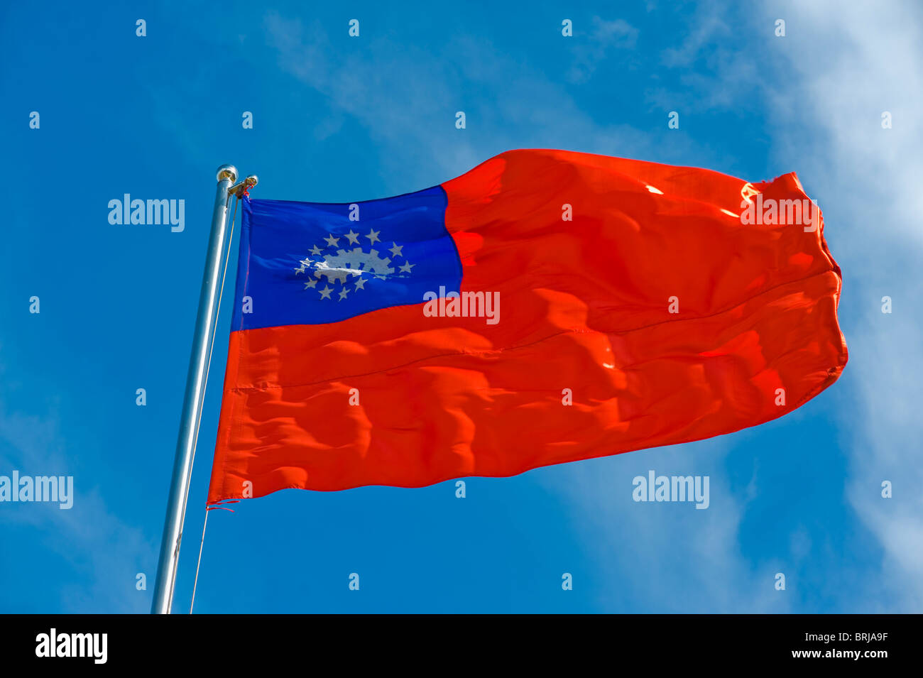 burmese flag on a pole against blue sky Stock Photo - Alamy