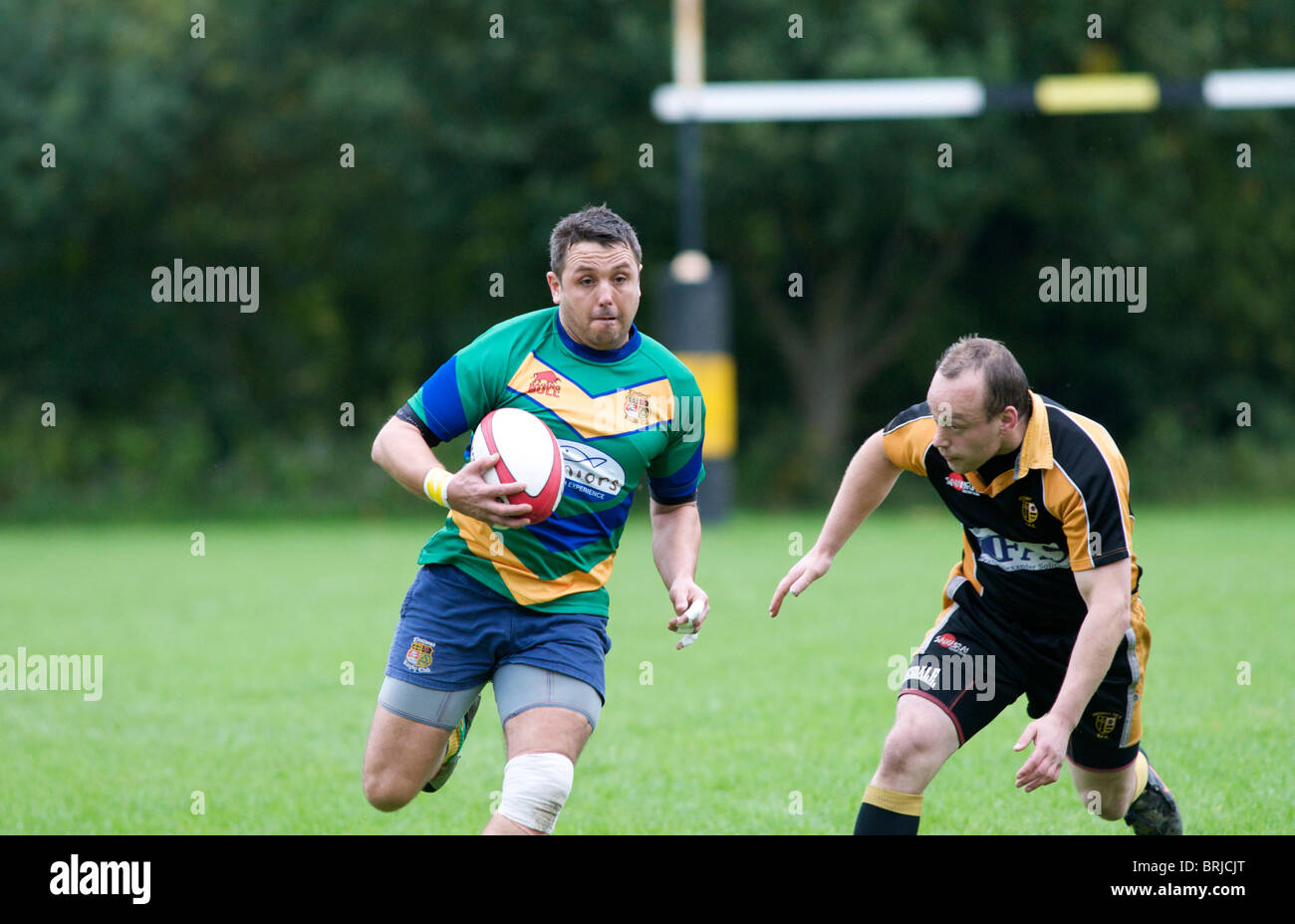 rugby player running with ball about to be tackled Stock Photo Alamy