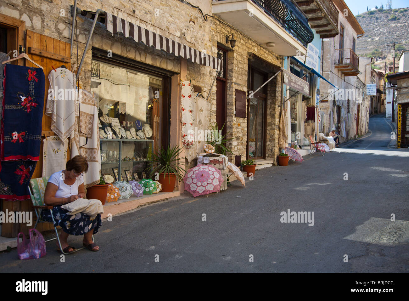 Woman creating embroidered crafts at shop entrance in the village of Lefkara, Cyprus Stock Photo