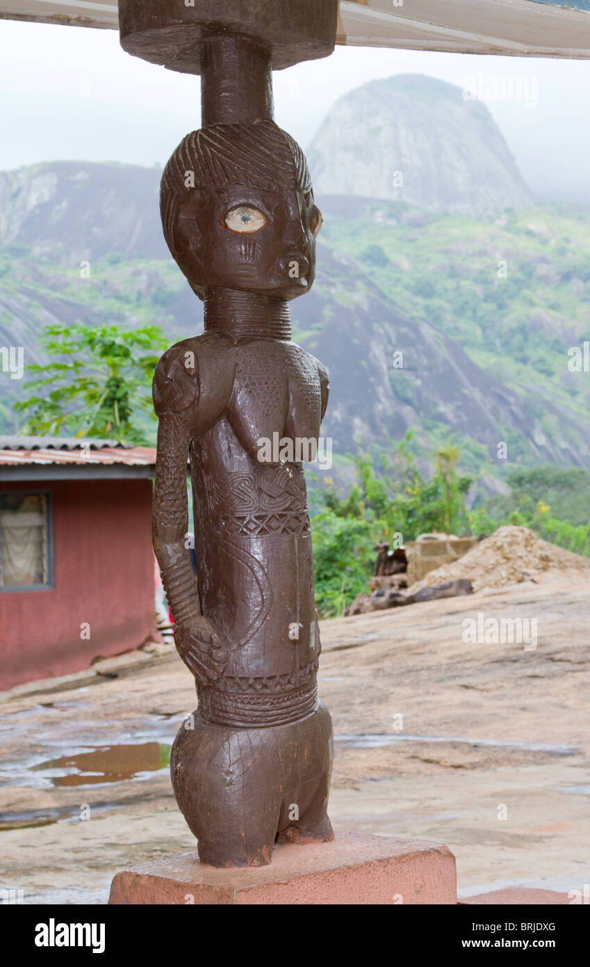 A traditional wooden figurel near a house in remote rural area of Nigeria, Ondo State, Idanre Hills. Stock Photo