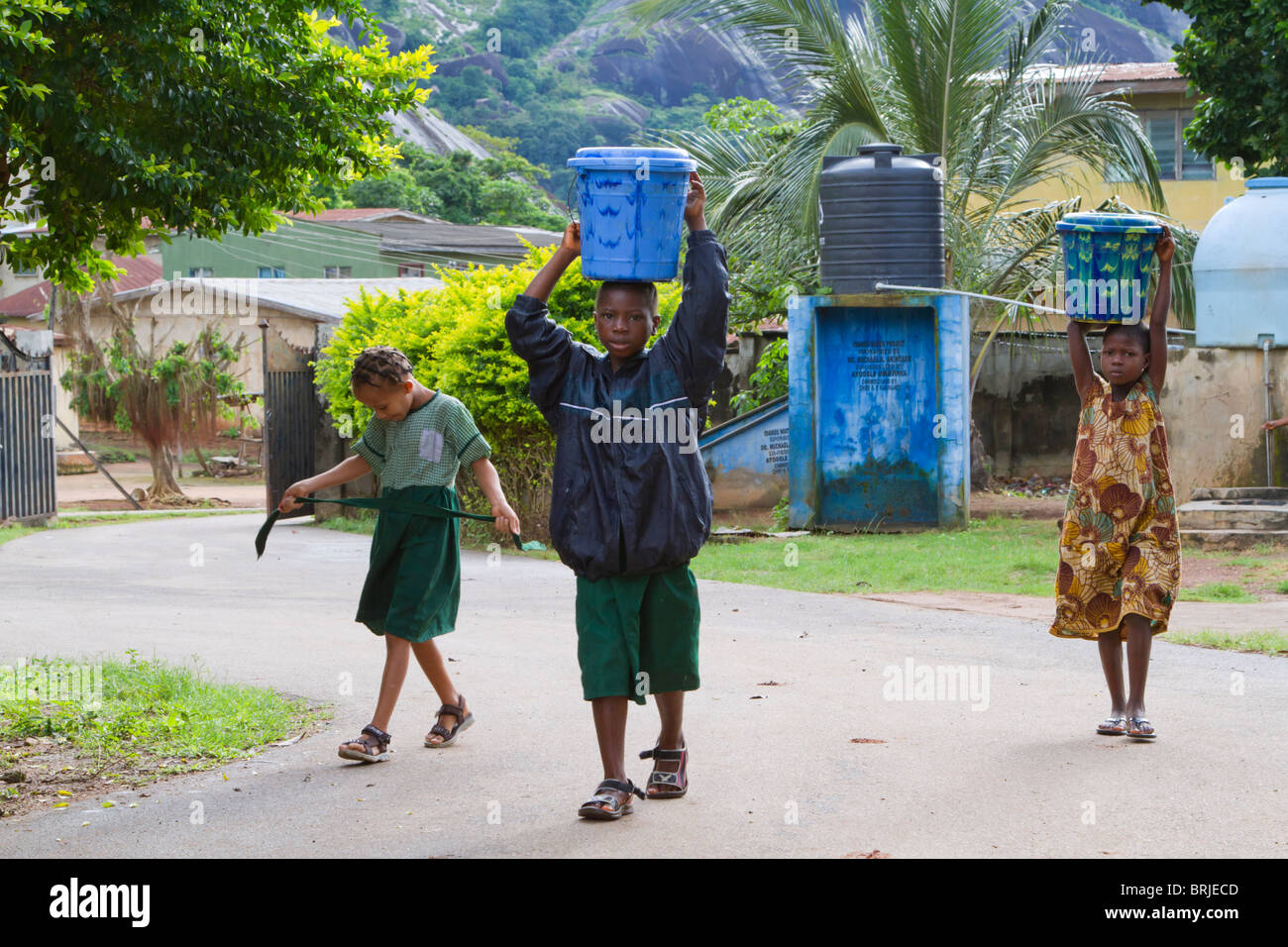 African children bearing buckets of water on their heads, Ondo State