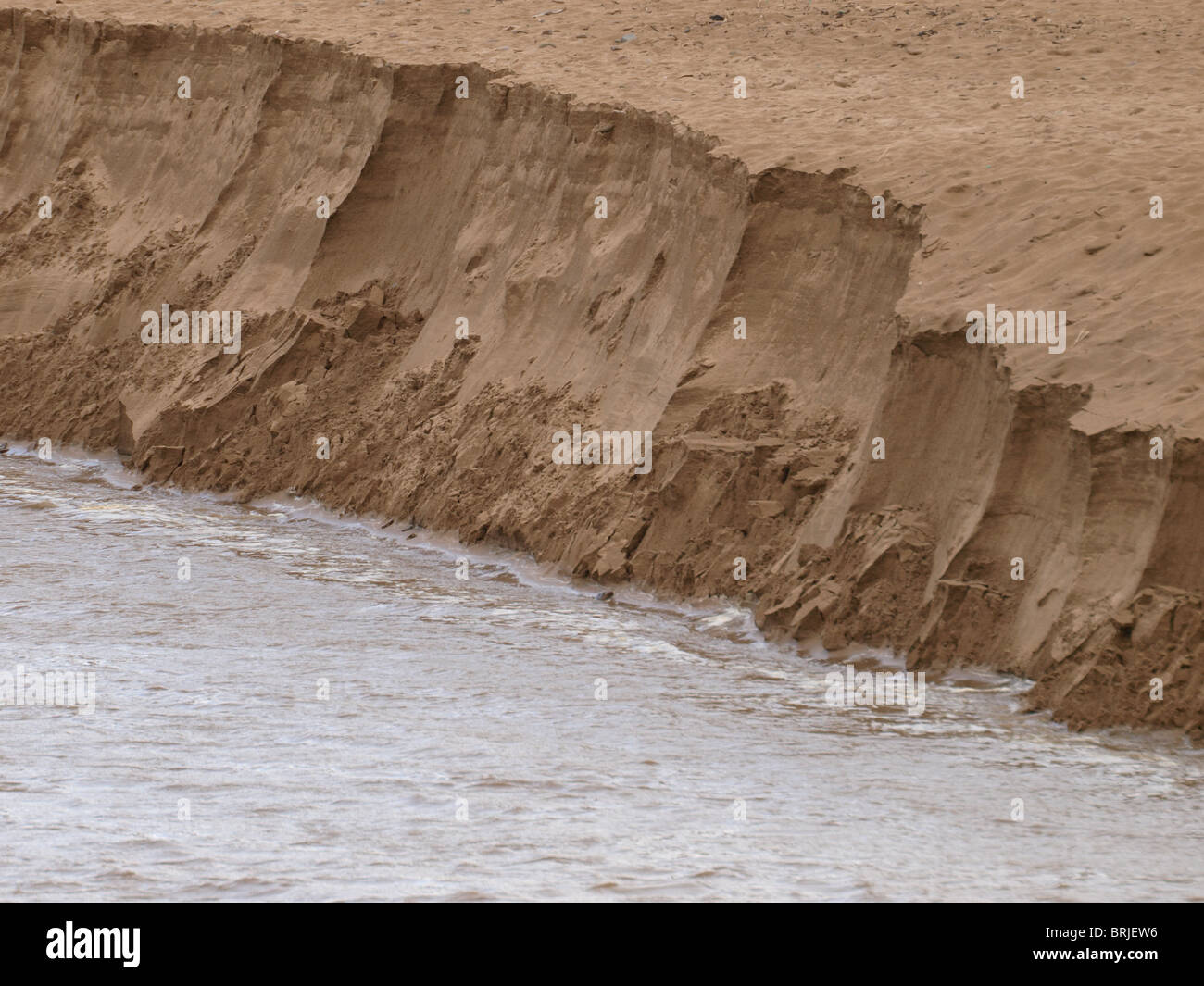 Swollen river eroding sand bank after heavy rains, Bude, Cornwall, UK Stock Photo