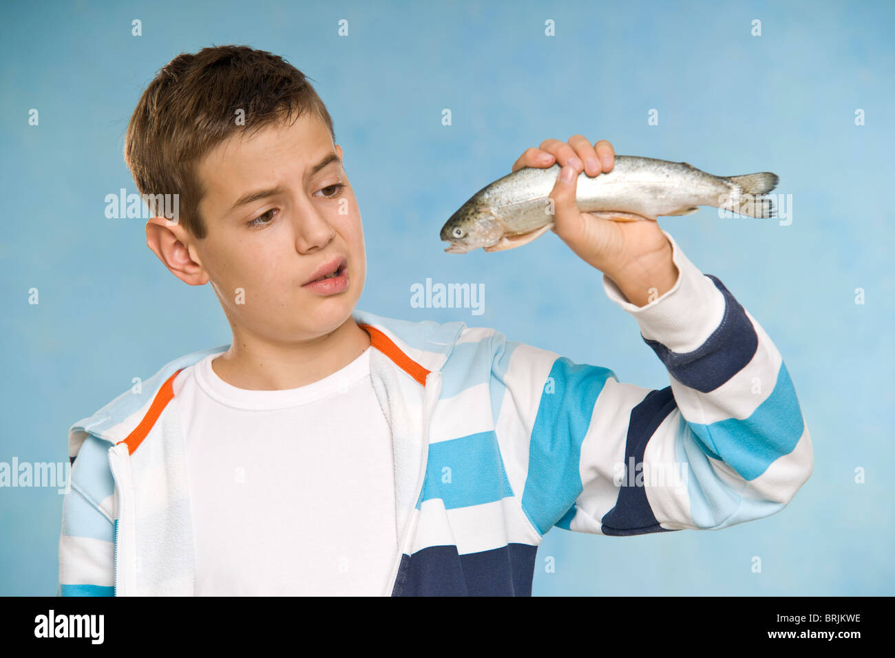 Boy holding fish white background hi-res stock photography and