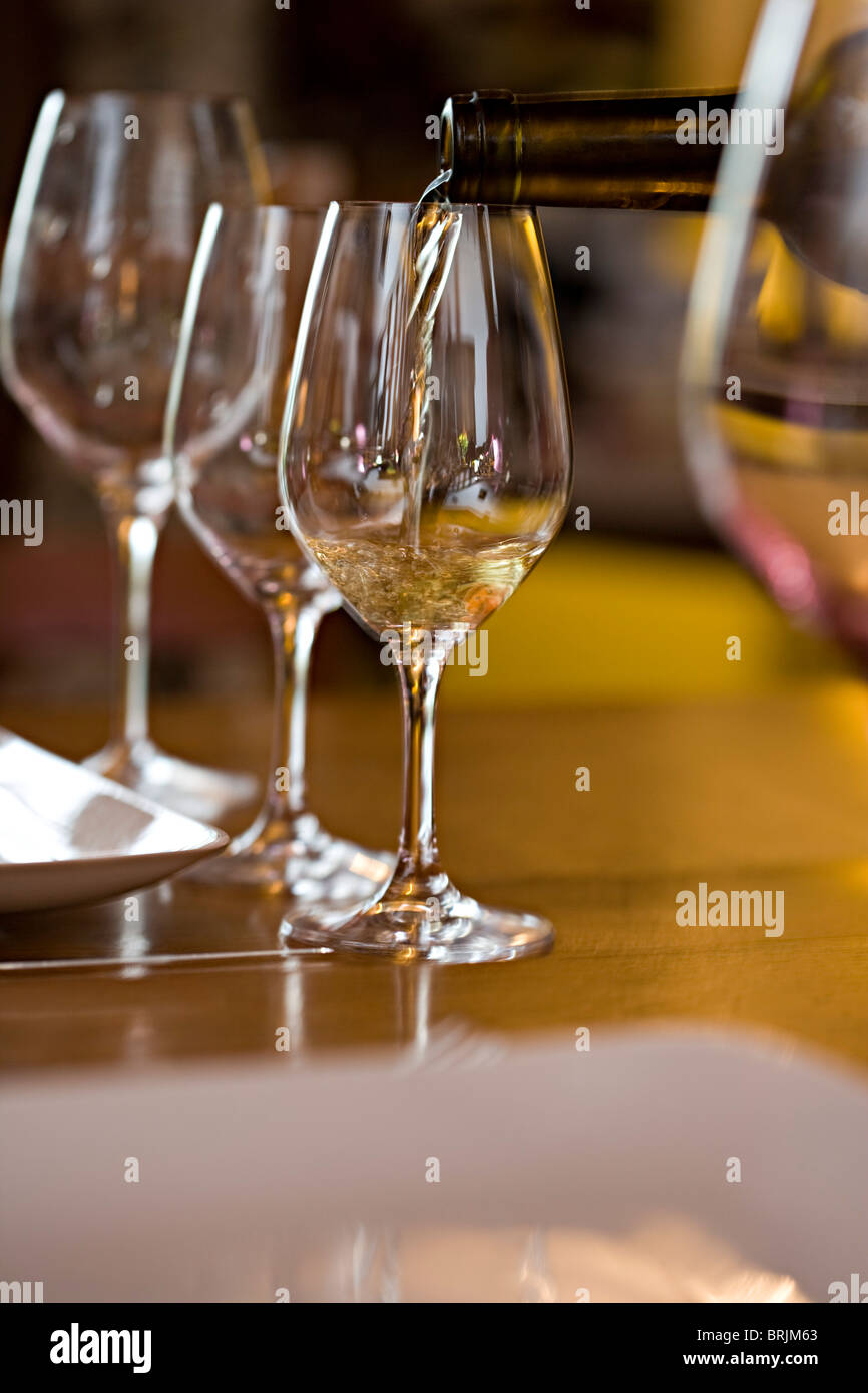 Pouring glasses of white wine Stock Photo