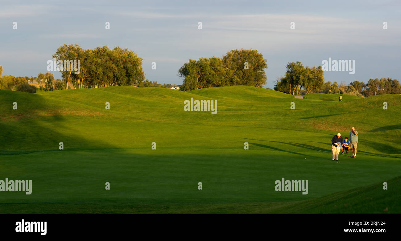 Two players on a green colf course Stock Photo