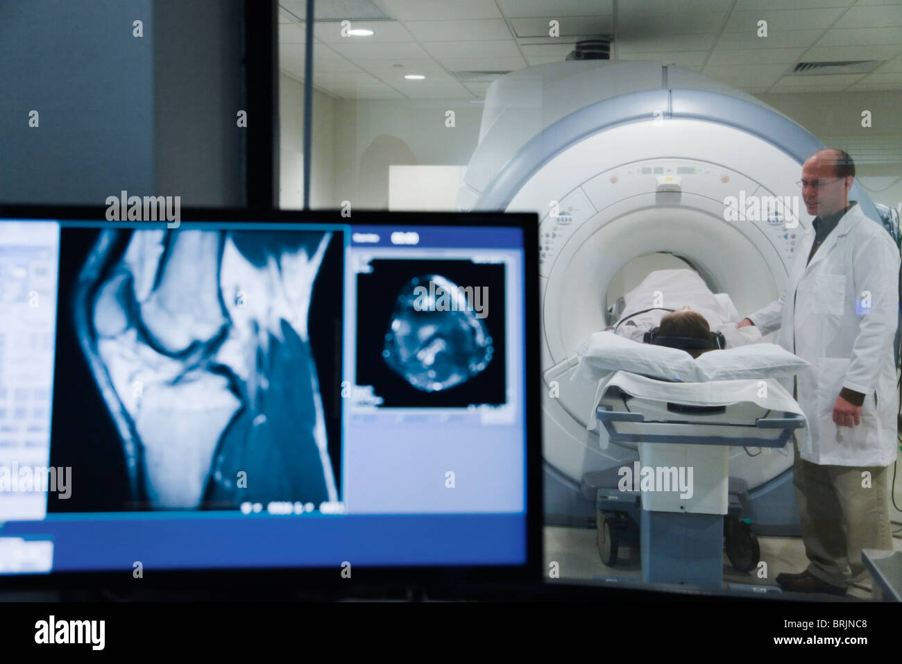 Doctor monitoring patient undergoing MRI scan Stock Photo