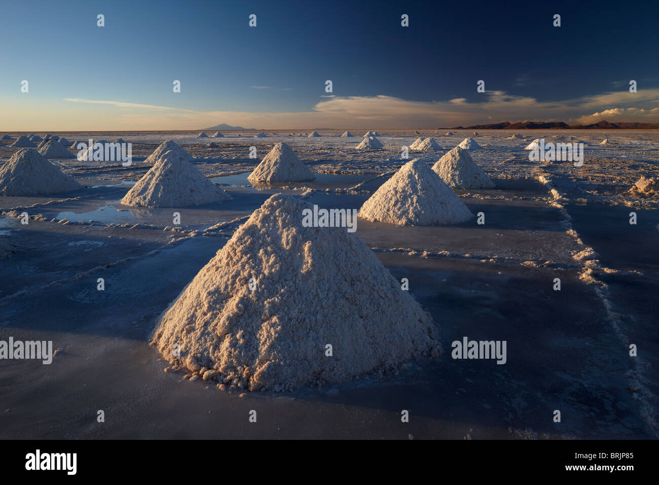 piles of salt on the Salar de Uyini at dusk, Bolivia Stock Photo