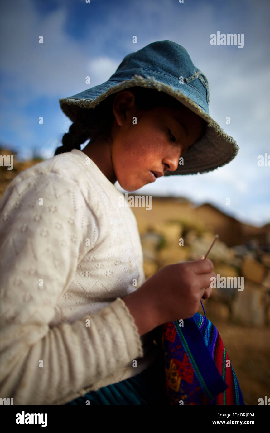 a girl stitching, Isla del Sol, Lake Titicaca, Bolivia Stock Photo