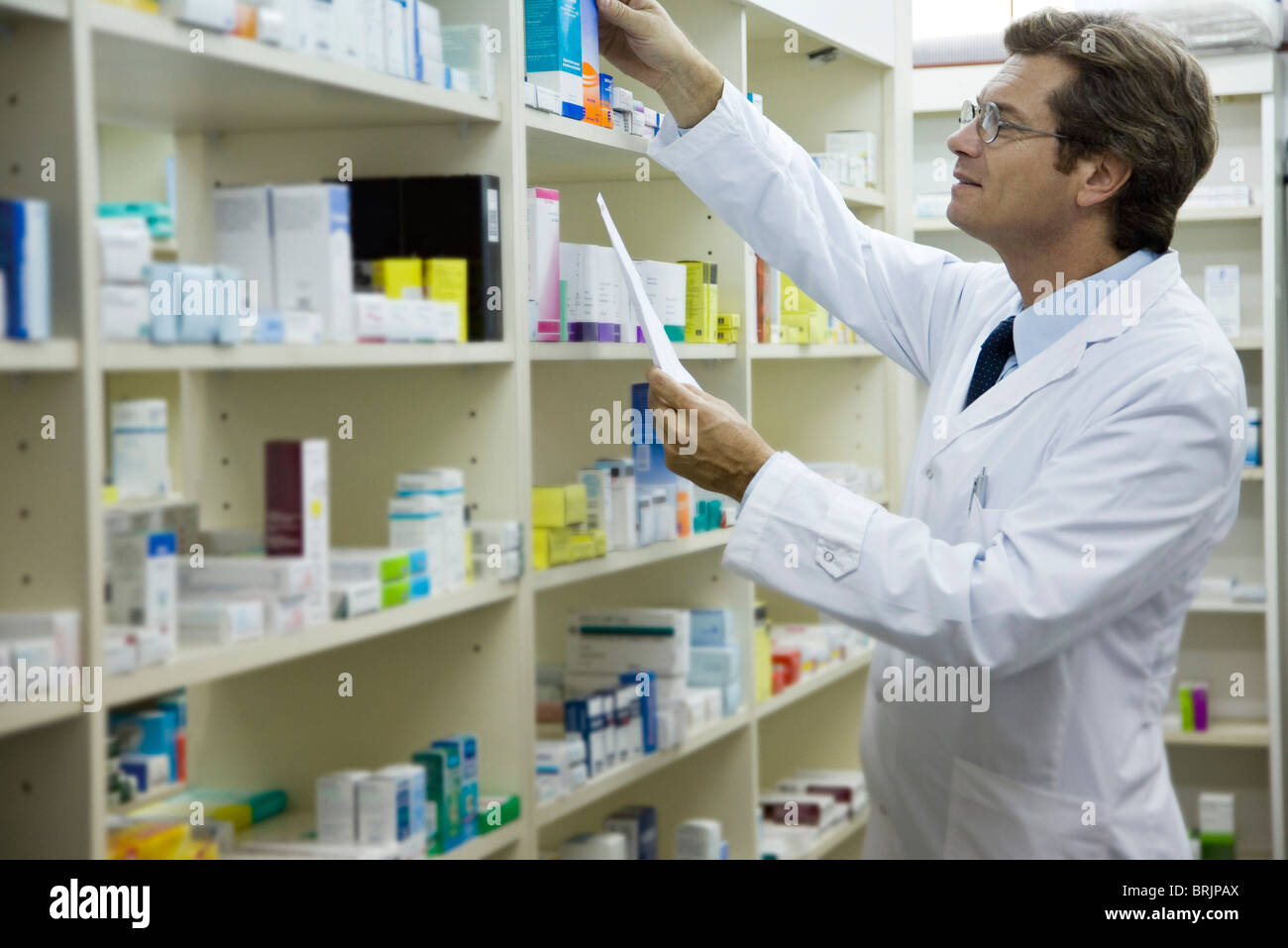 Pharmacist checking shelf for medication Stock Photo Alamy