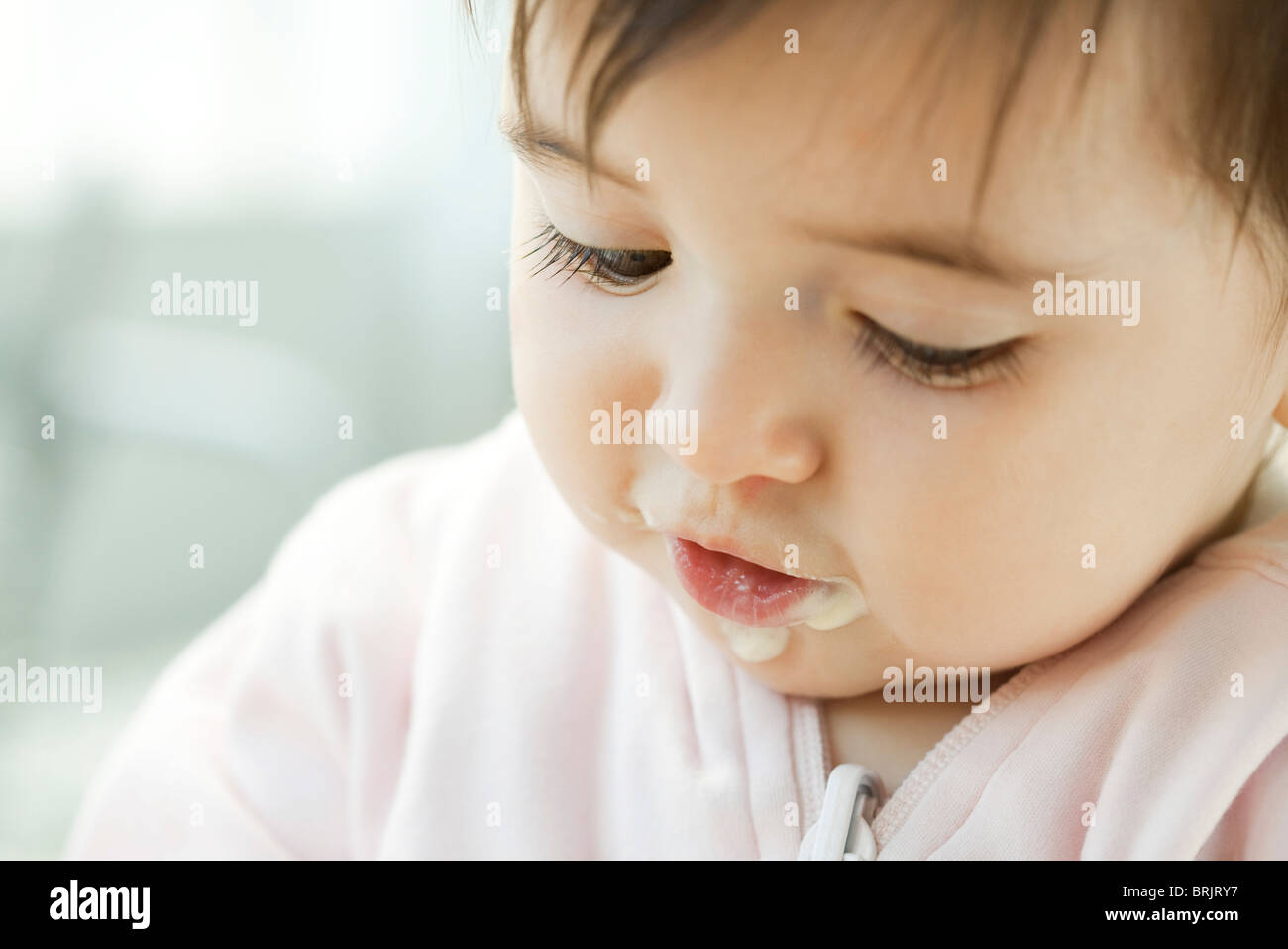 Infant with baby food on her face, portrait Stock Photo