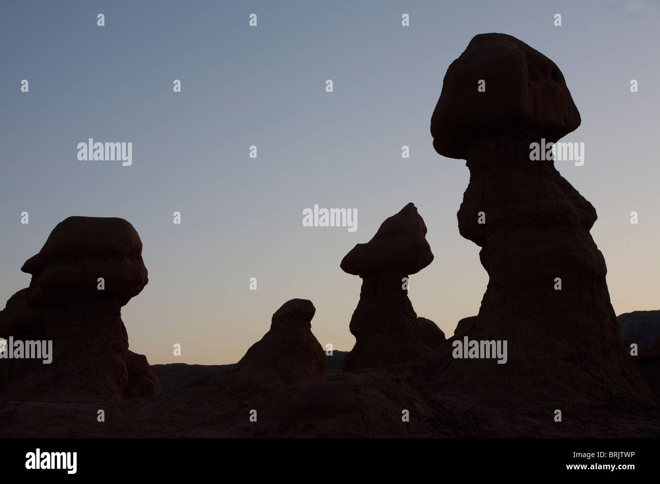 Hoodoos are individual, small rock formations, silhouetting the sky in Goblin Valley State Park, Utah. Stock Photo