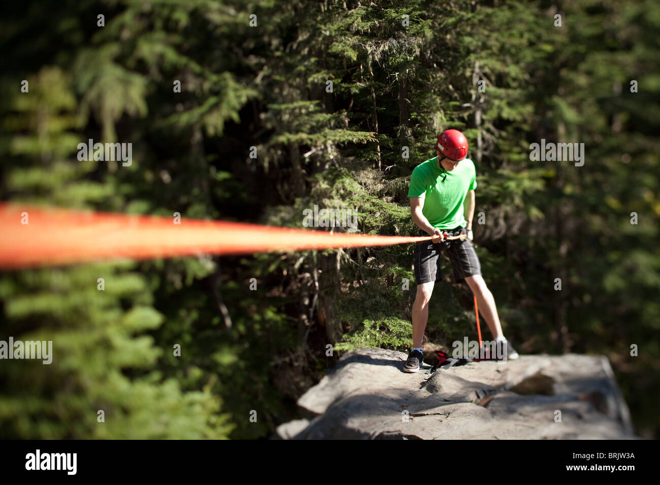 A young man prepares to rappel down a cliff in Idaho Stock Photo Alamy