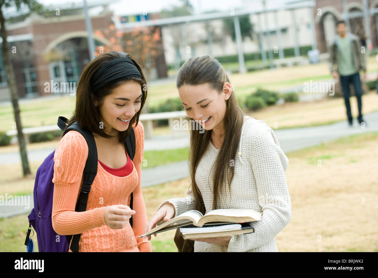 High school friends looking at book together Stock Photo Alamy