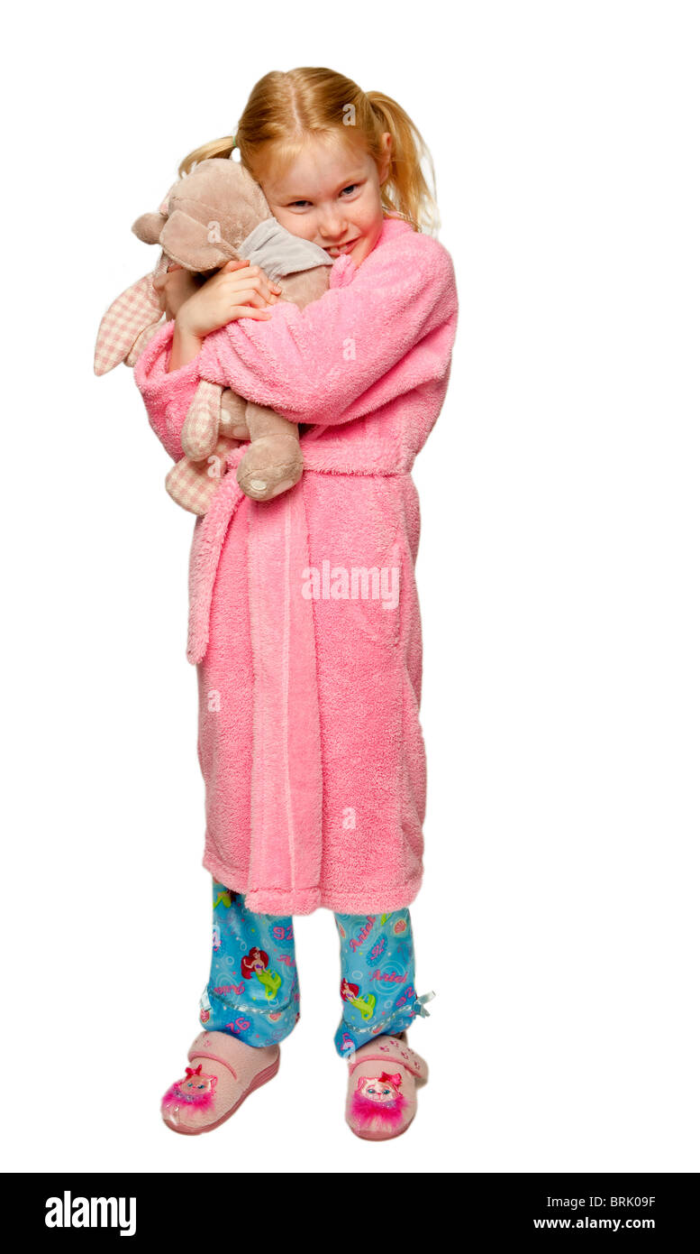 Little, small, young,caucasian girl in her pyjamas, slippers and dressing  gown ready for bed cuddling her toy Stock Photo - Alamy