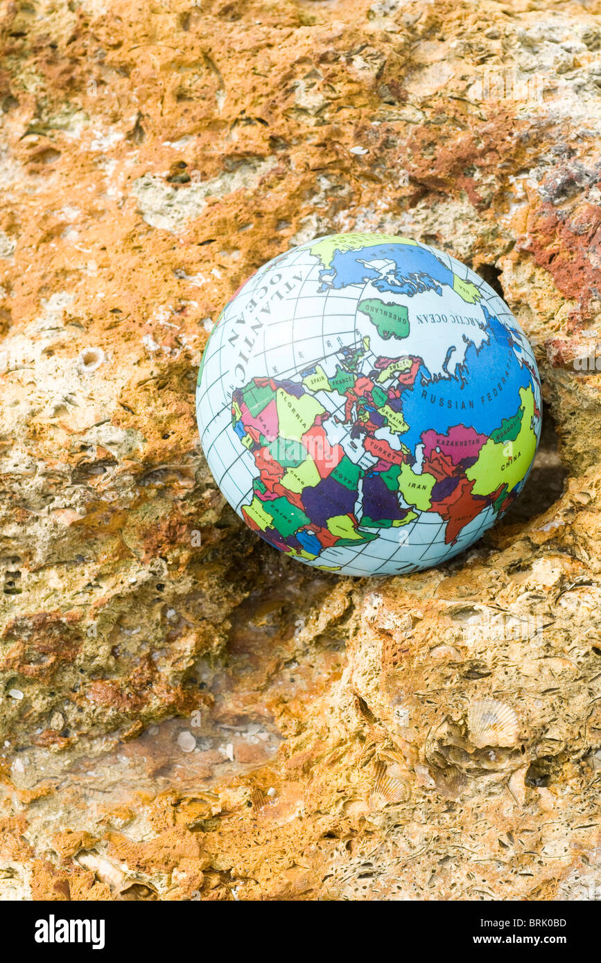 Globe nestled in rock Stock Photo