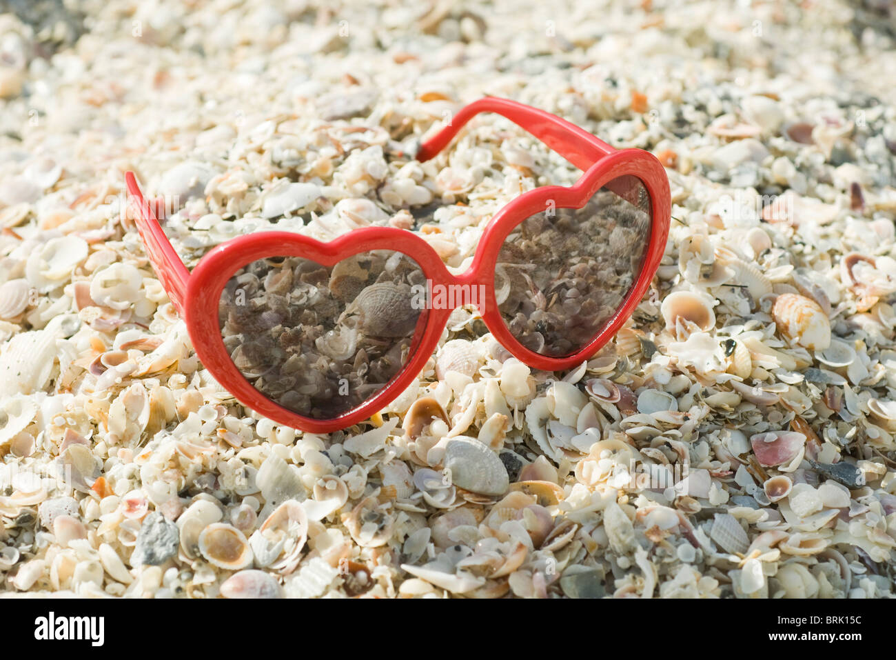Heart-shaped sunglasses on beach Stock Photo
