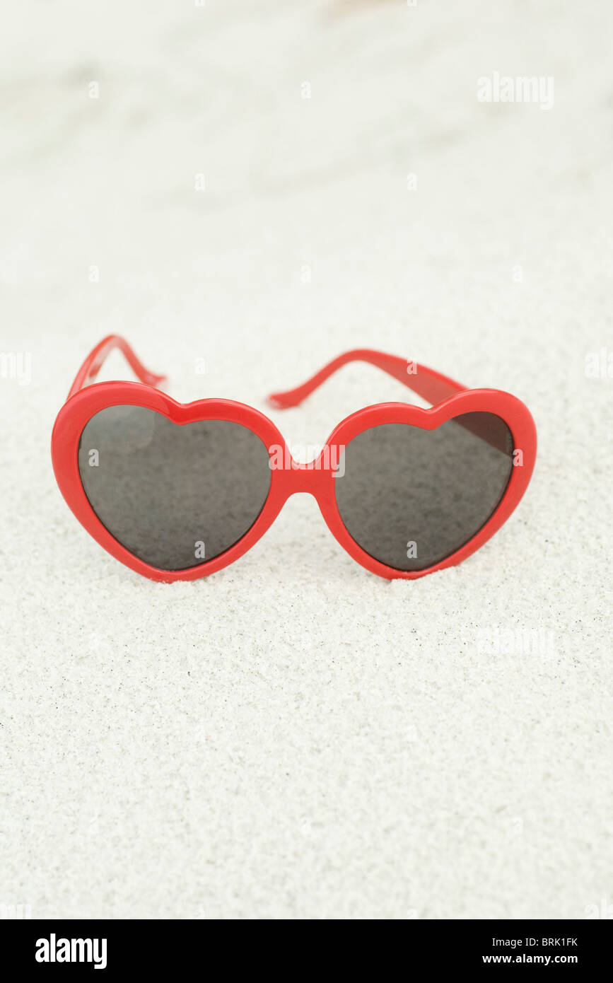 Heart-shaped sunglasses on beach Stock Photo