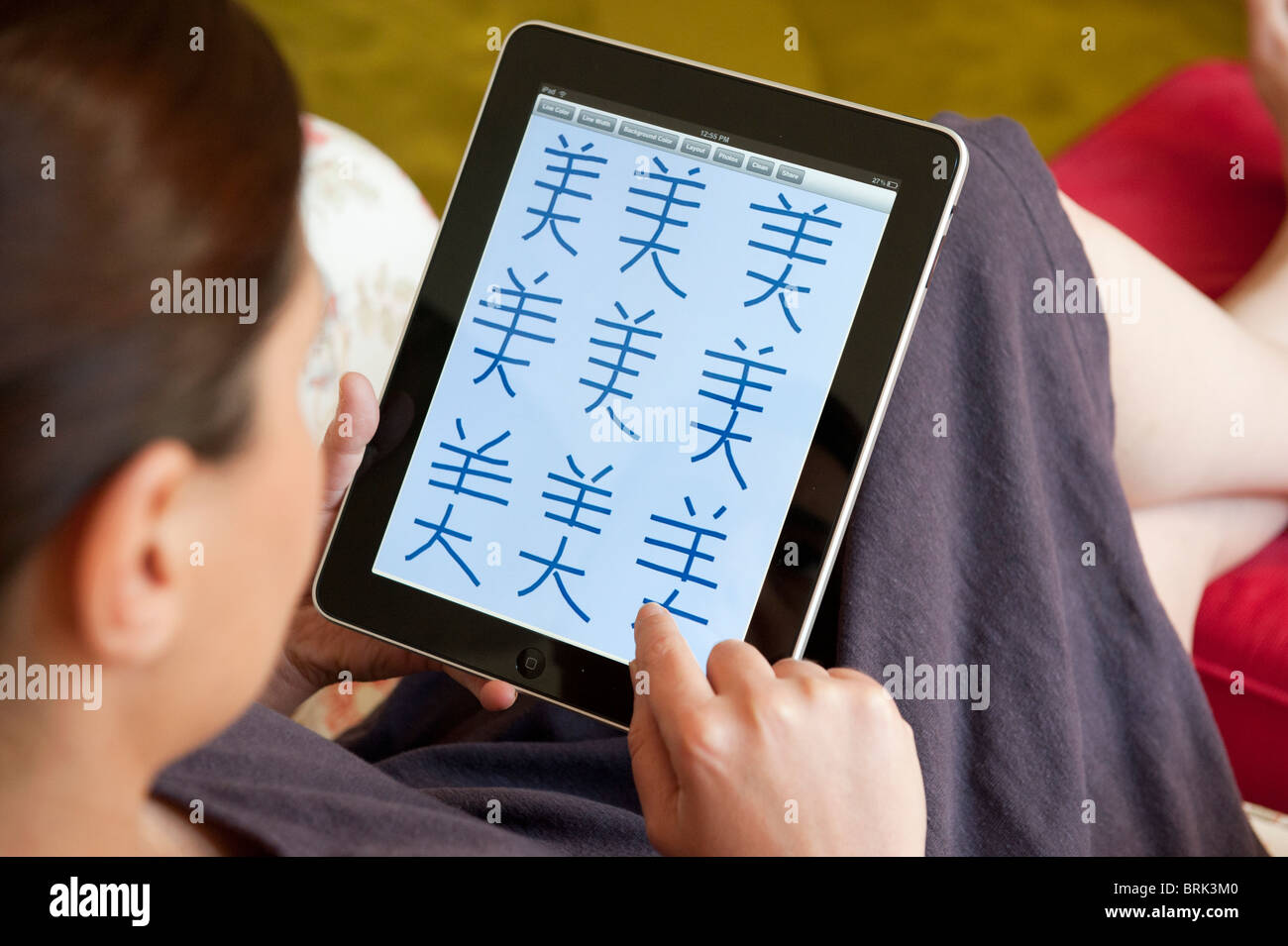 Woman practicing to write mandarin Chinese characters on an iPad
