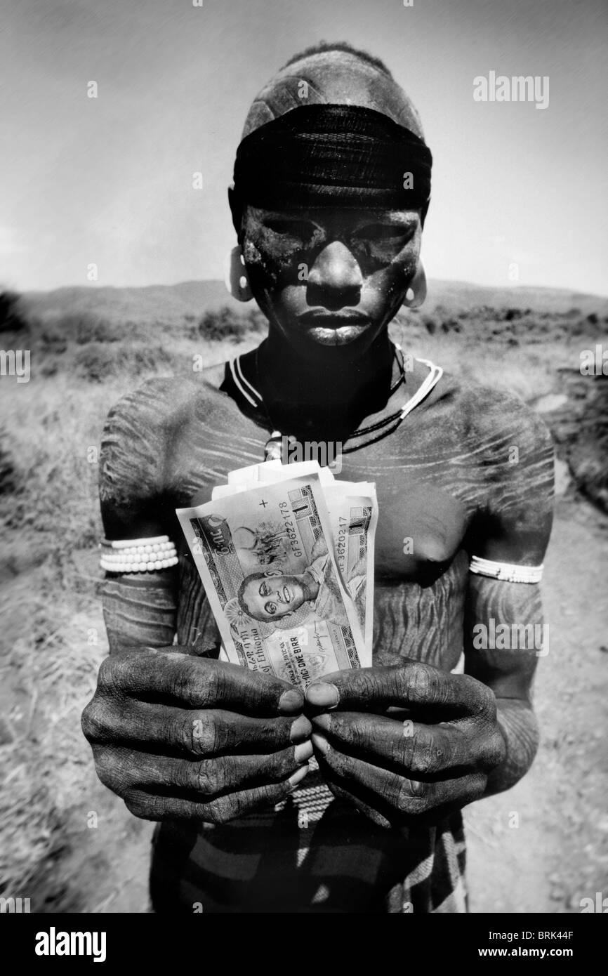 Child labor, mursi boy with birr, Jinka, Etiopia Stock Photo