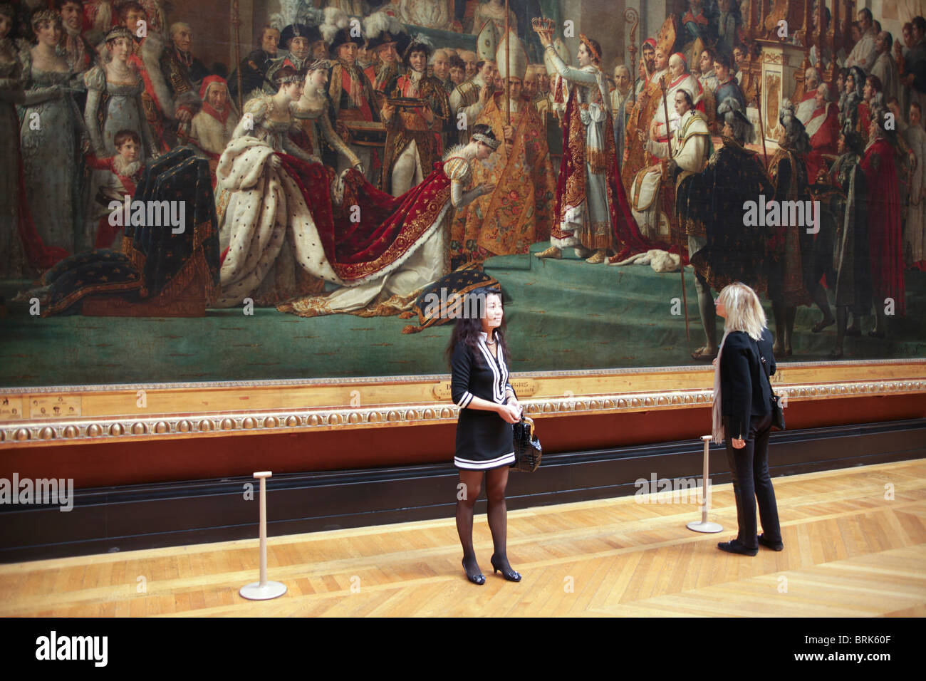 Japanese tourist in front of painting by JacquesLouis David in Louvre