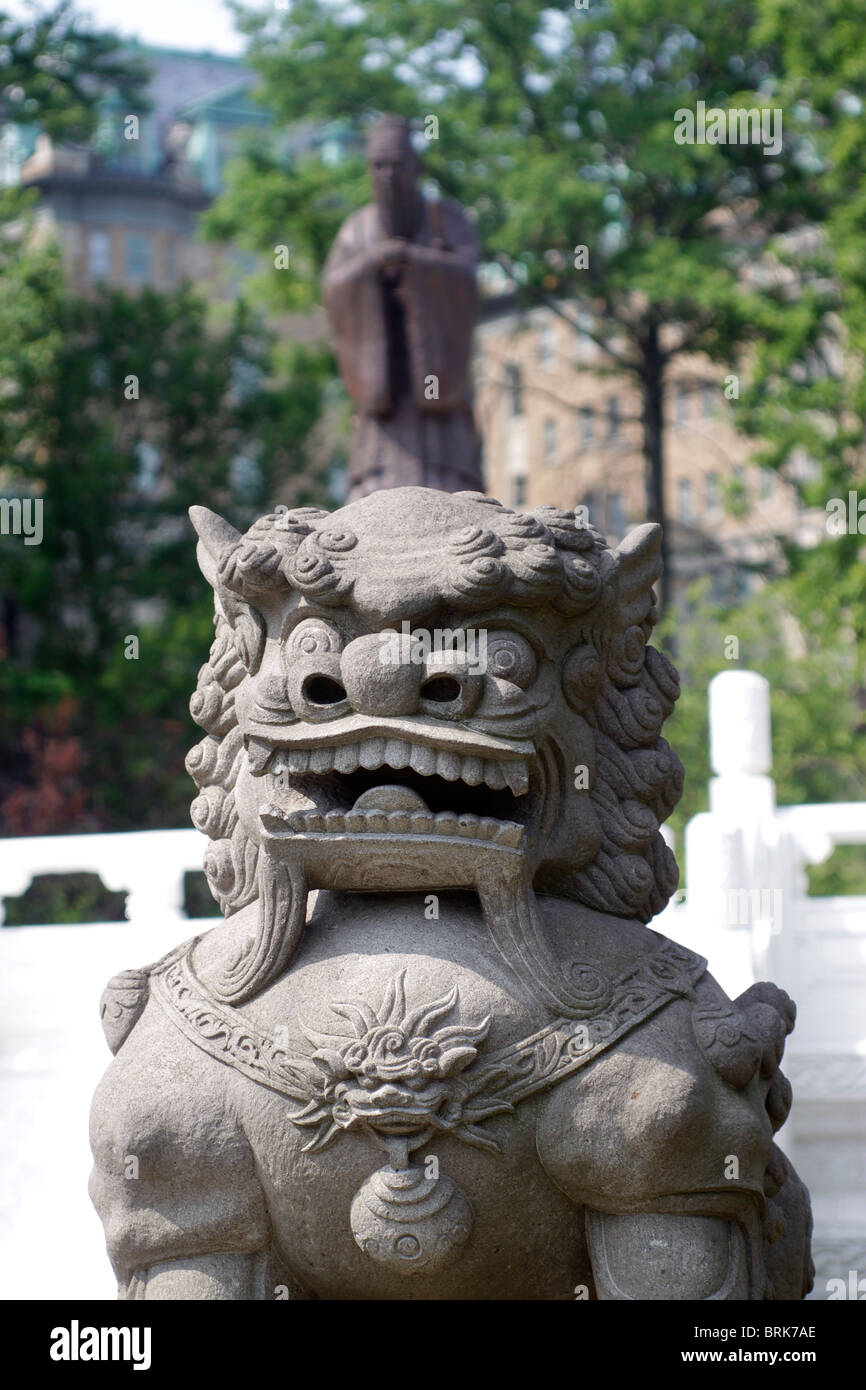 Chinese Lion with statue of Confusious in background Chinese cultural garden Cleveland Ohio Stock Photo